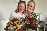2 Frauen stehen mit Blumenstrauß nebeneinander