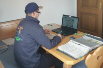 Studierender am Wohnzimmertisch mit Laptop